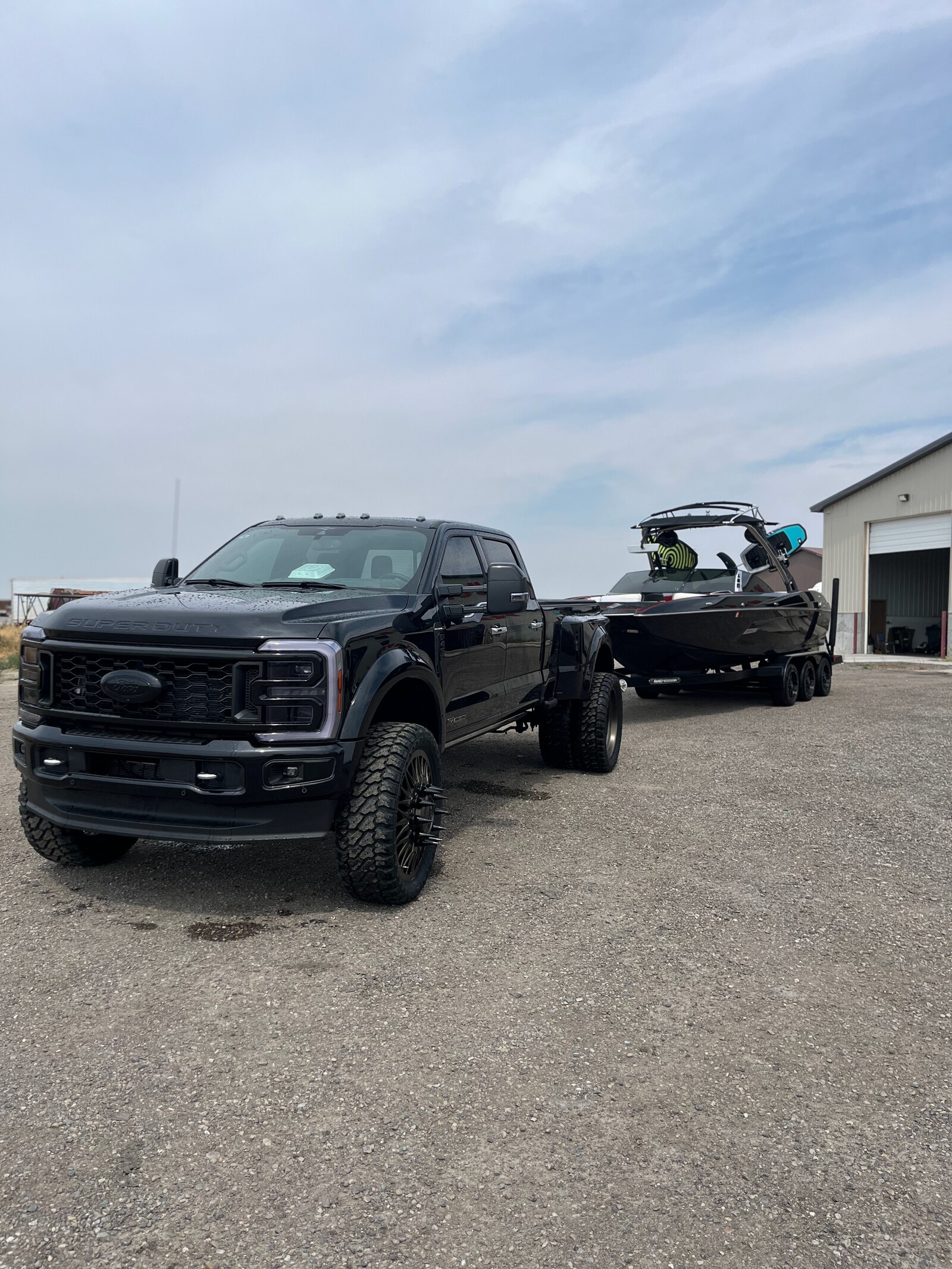 Black Ford dually with boat infront of Truck Wash building